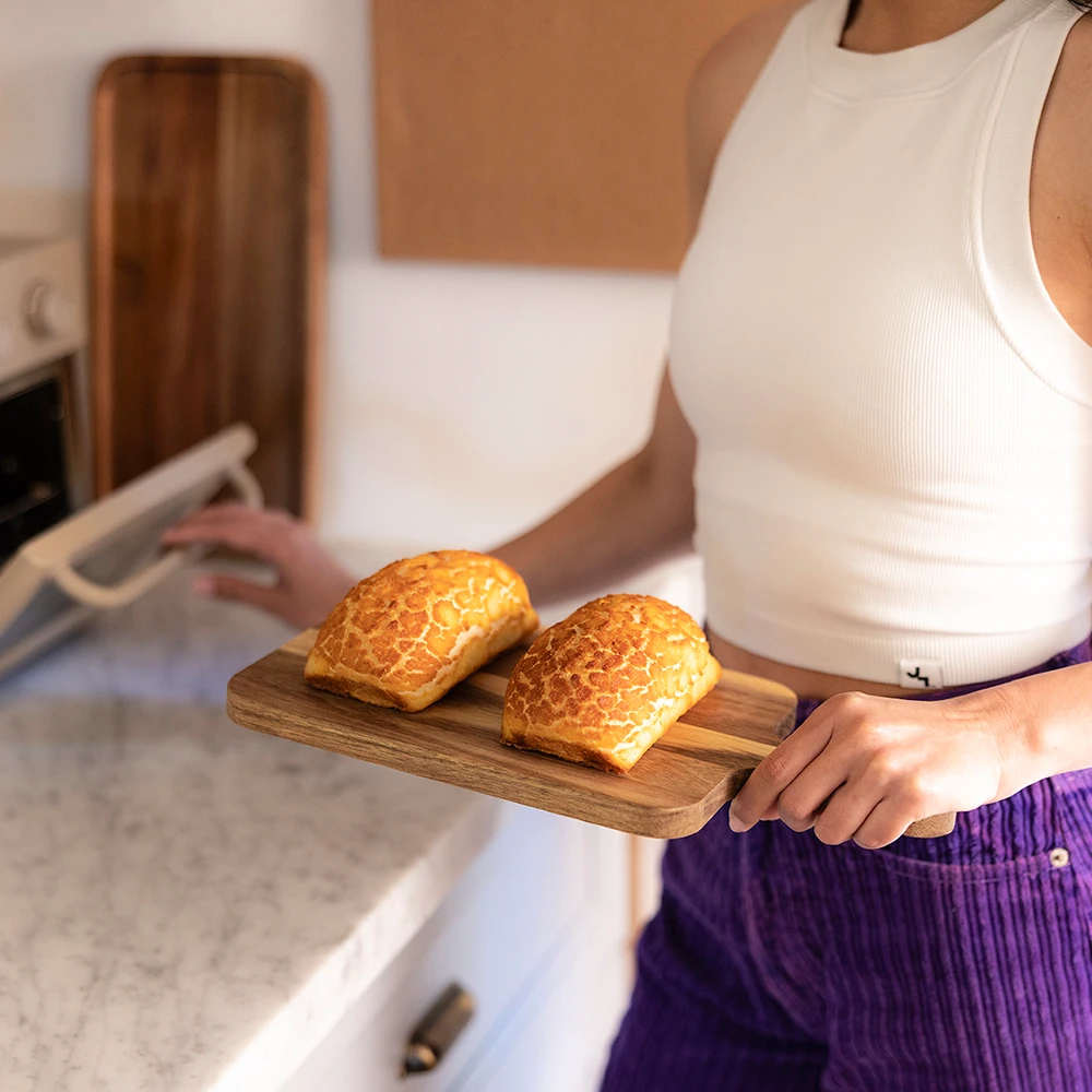 Girl holding Dutch Crunch bread and putting them in the oven